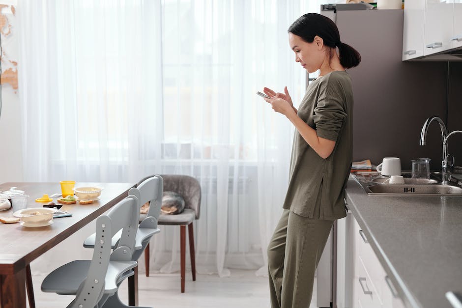 Woman Using her Phone in a Kitchen