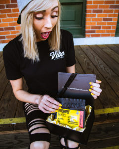 girl opening box of cannabis edibles